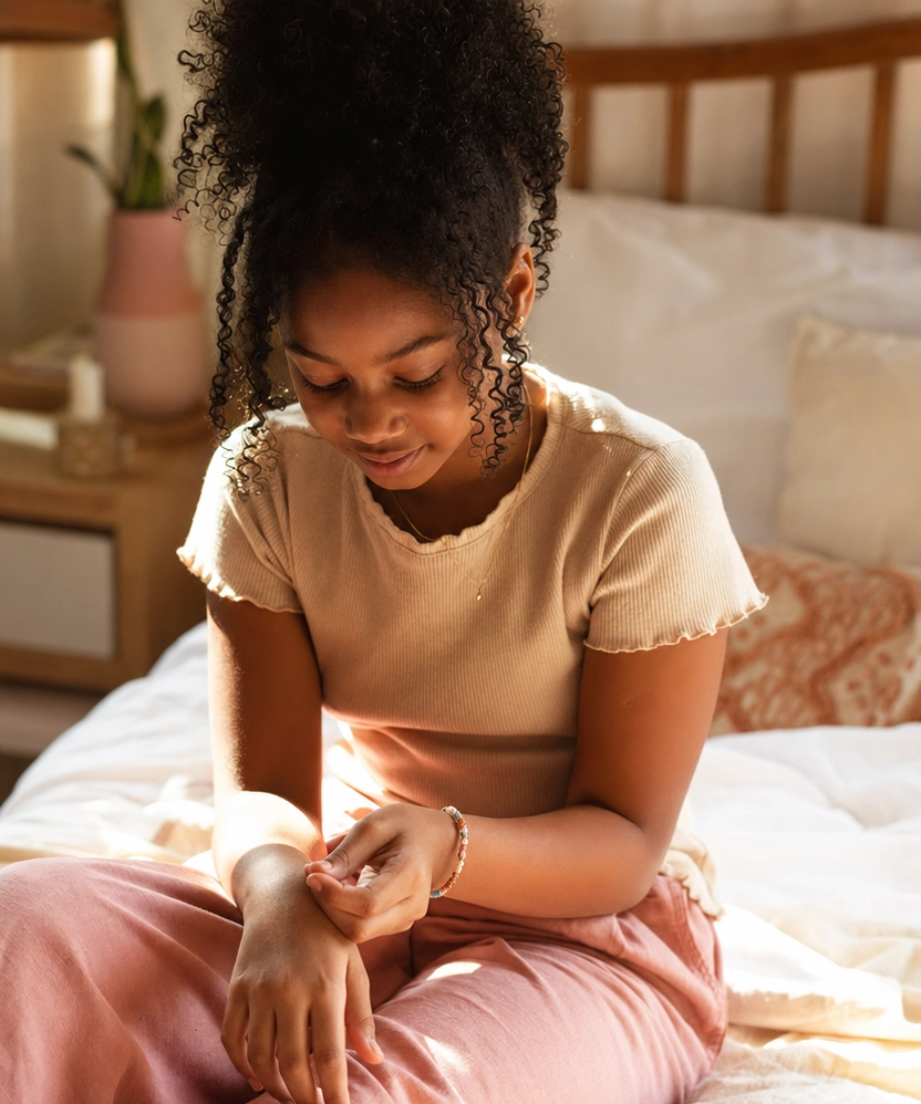 A girl admiring a delicate bracelet she received from her Big Sister Letter