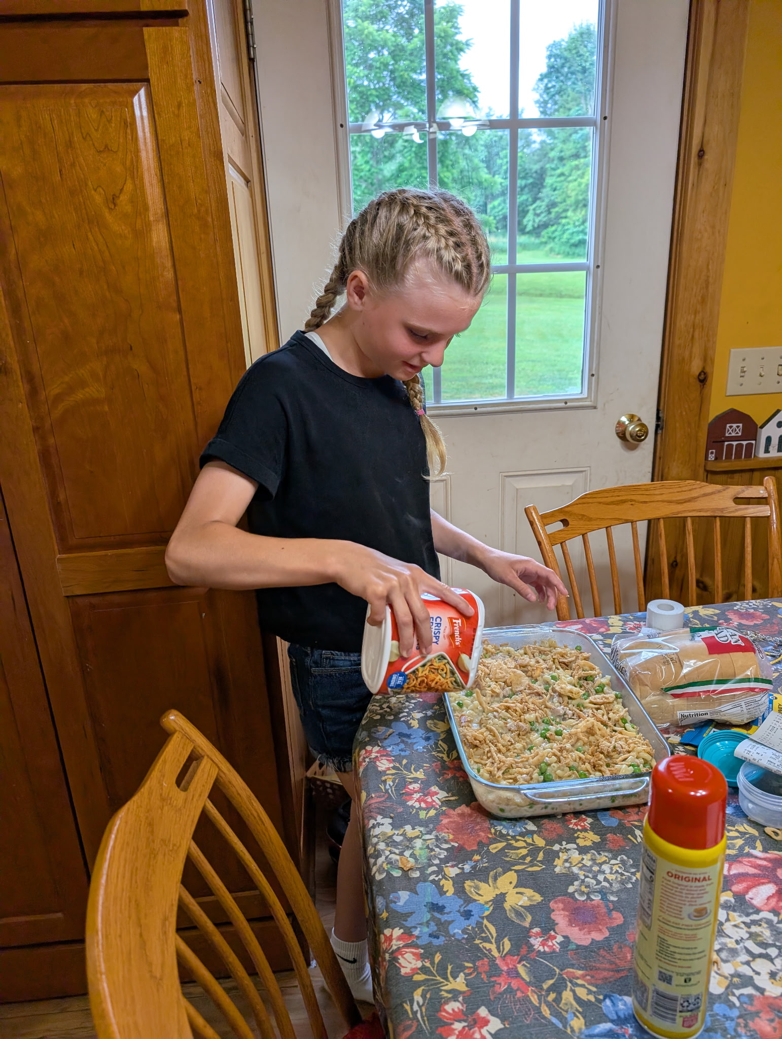 Mae adding crispy toppings to a tuna noodle casserole after reading her Big Sister Letter